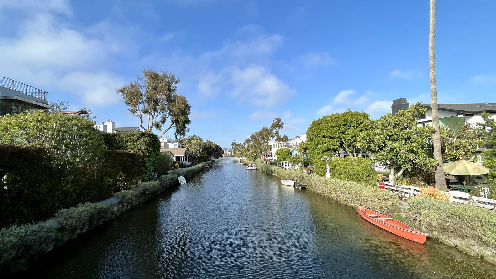 The Venice Canals Historic District in Venice, California, with waterfront homes and a red canoe along the water